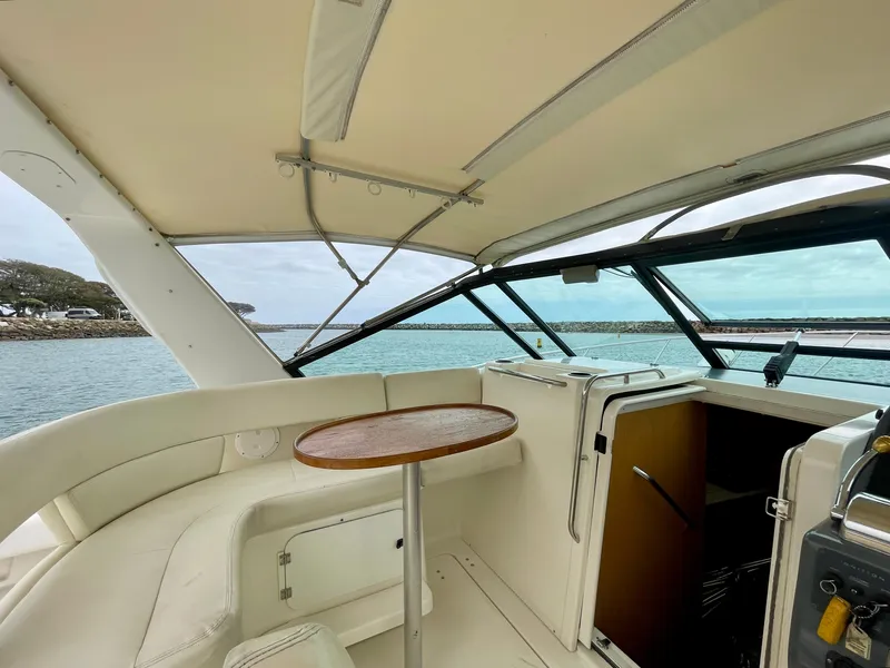 Slide: The Image of 1998 Tiara Yachts 3100 Open interior with seating and table, overlooking serene waters. - 20