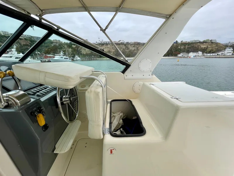 Slide: The Image of 1998 Tiara Yachts 3100 Open helm with storage, docked in a scenic marina. - 23