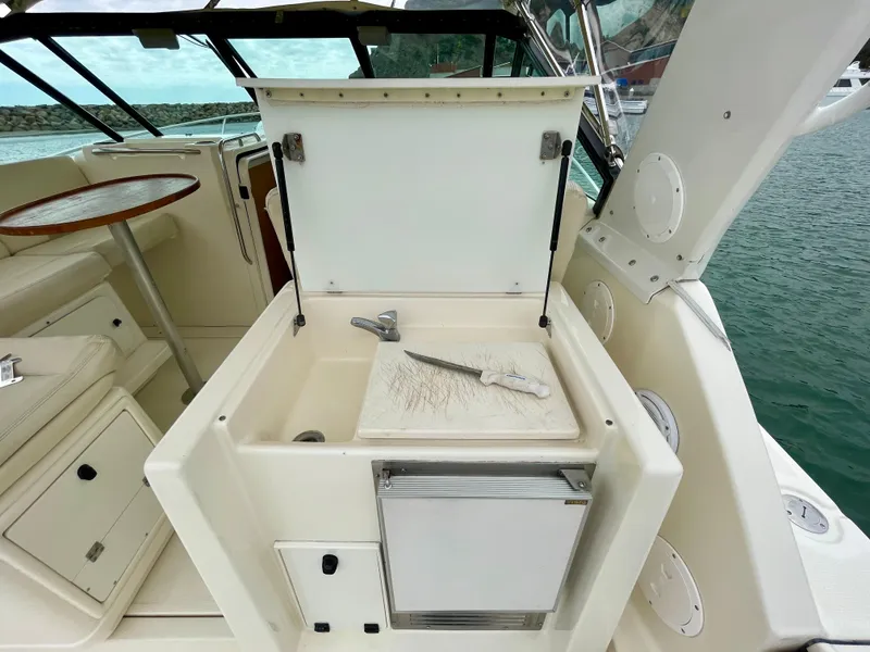 Slide: The Image of 1998 Tiara Yachts 3100 Open interior with open storage compartment and cutting board. - 24