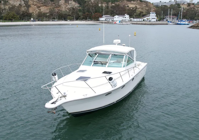 Slide: The Image of 1998 Tiara Yachts 3100 Open cruising in a serene harbor setting. - 3