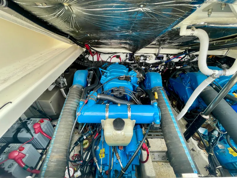 Slide: The Image of Engine compartment of 1998 Tiara Yachts 3100 Open, showcasing dual blue engines. - 30