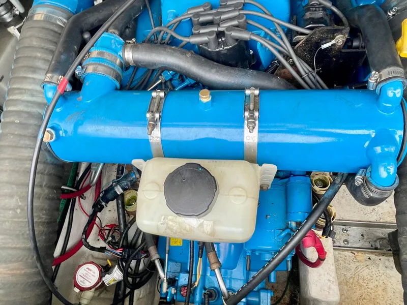 Slide: The Image of Engine compartment of a 1998 Tiara Yachts 3100 Open, featuring blue components and hoses. - 32