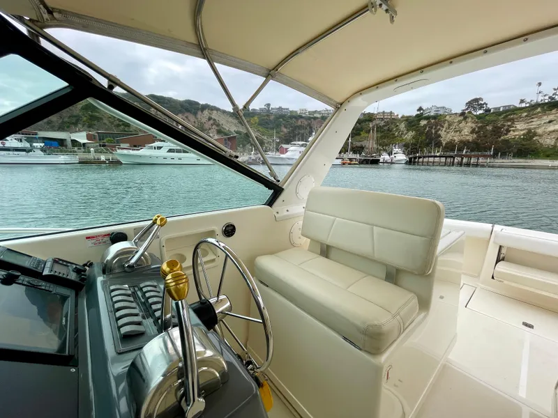 Slide: The Image of 1998 Tiara Yachts 3100 Open cockpit with steering wheel, docked in marina. - 38