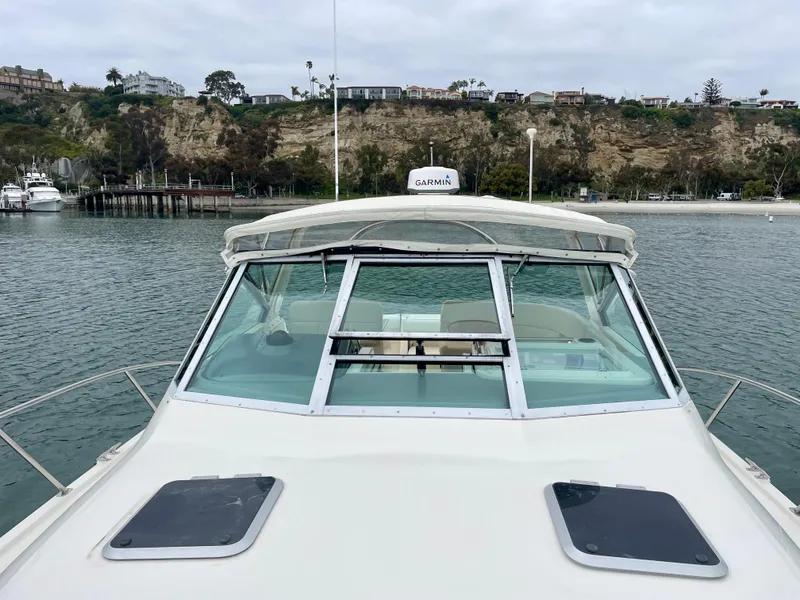 Slide: The Image of 1998 Tiara Yachts 3100 Open boat on calm water, coastal background. - 40