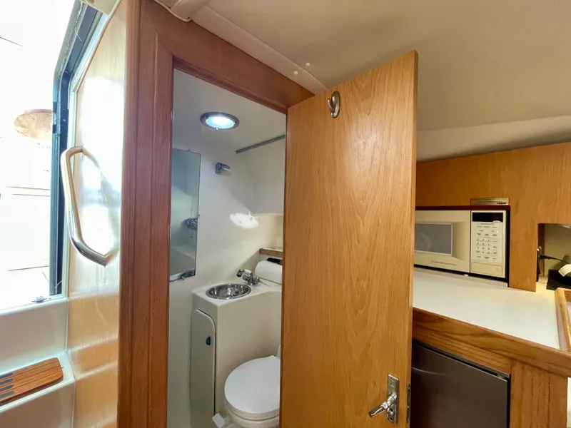 Slide: The Image of 1998 Tiara Yachts 3100 Open interior with bathroom and kitchenette. - 43