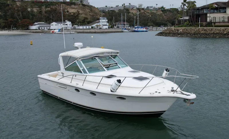 Slide: The Image of 1998 Tiara Yachts 3100 Open cruising in a calm harbor. - 8
