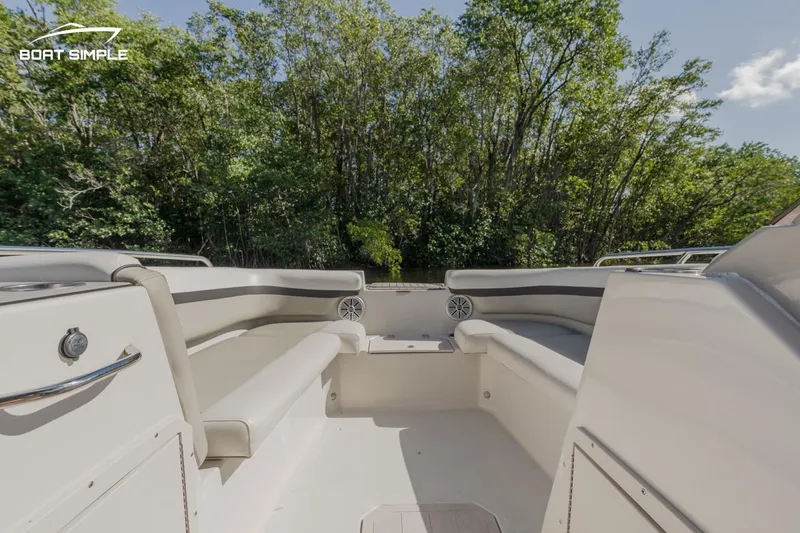 Slide: The Image of 2023 Starcraft SVX 211 OB boat interior with seating, surrounded by lush greenery. - 9