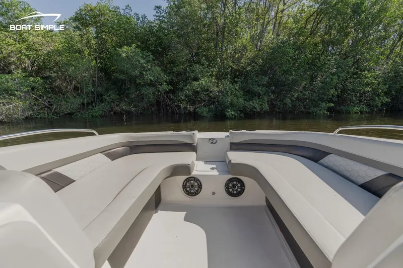 Slide: The Image of 2022 Hurricane SunDeck 217 OB boat interior with spacious seating, surrounded by lush greenery. - 5