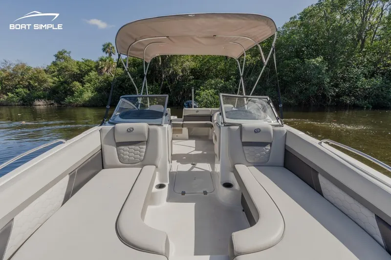 Slide: The Image of 2022 Hurricane SunDeck 217 OB boat interior with canopy, on a calm river. - 6