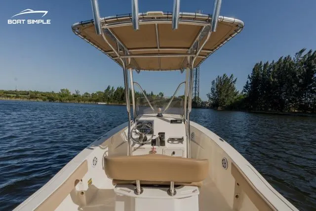 Slide: The Image of 2022 Scout 195 Sportfish boat on a serene lake with clear blue skies. - 5