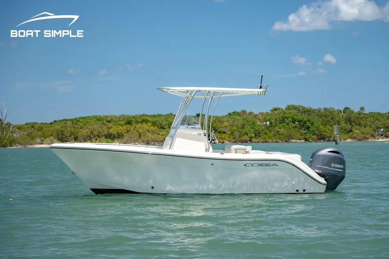 Slide: The Image of 2021 Cobia 201 Center Console boat on calm water, clear sky background. - 2