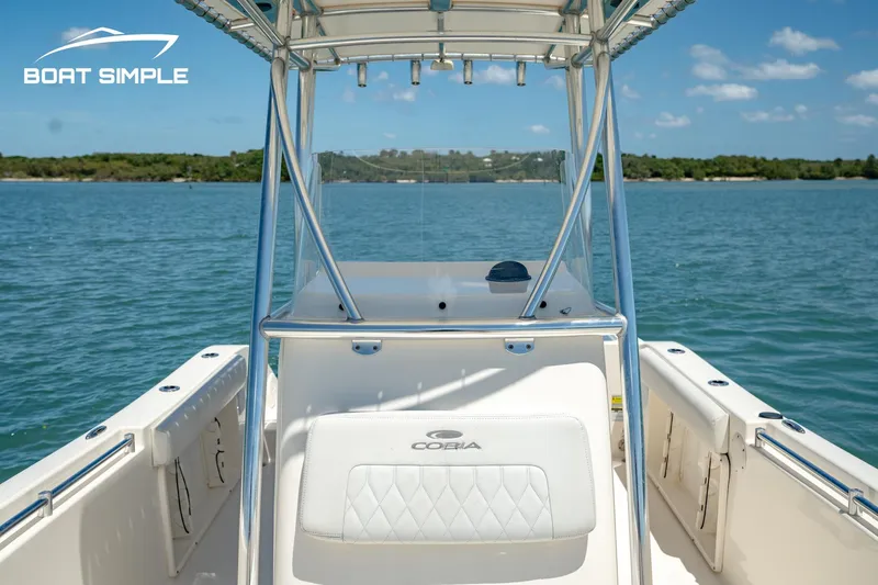 Slide: The Image of 2021 Cobia 201 Center Console boat on calm water, clear sky, and distant shoreline. - 4