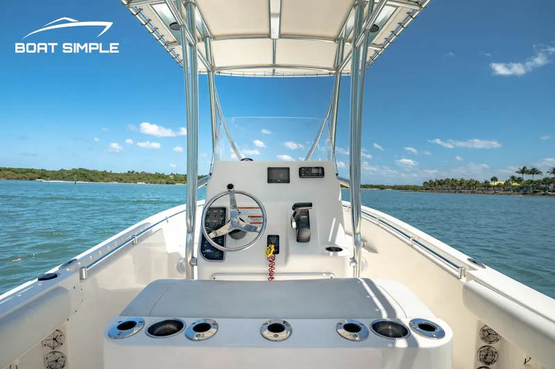 Slide: The Image of 2021 Cobia 201 Center Console boat on calm water under clear blue sky. - 6