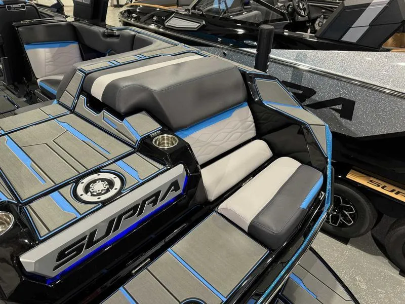Slide: The Image of 2025 Supra SA boat interior with sleek gray and blue seating design. - 15