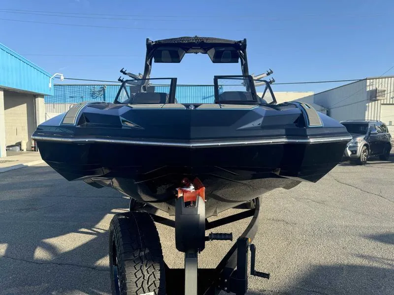 Slide: The Image of 2025 Supra SA boat on trailer, parked outdoors under clear blue sky. - 4