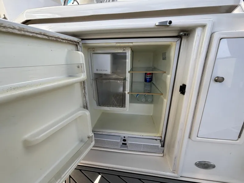 Slide: The Image of Open mini fridge on 2005 Cruisers Yachts 440 Express, containing a single soda can. - 10
