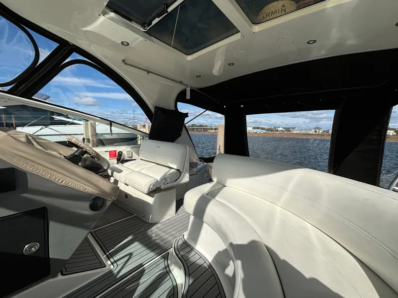 Slide: The Image of 2005 Cruisers Yachts 440 Express interior with white seating and water view. - 12
