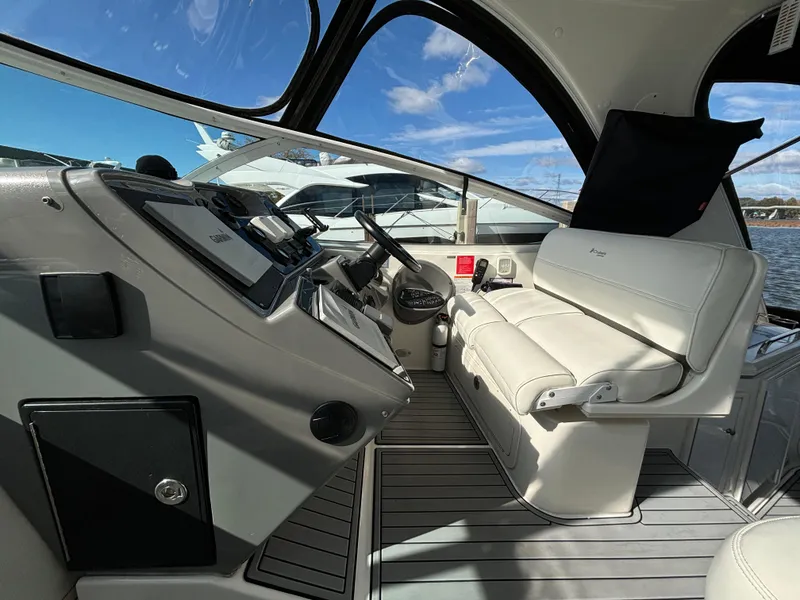 Slide: The Image of 2005 Cruisers Yachts 440 Express cockpit with modern controls and white seating. - 14