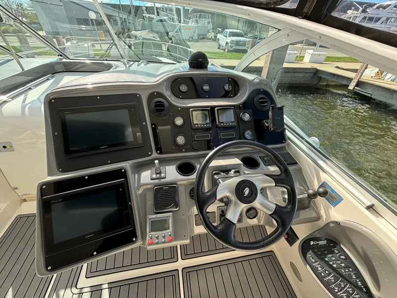 Slide: The Image of 2005 Cruisers Yachts 440 Express helm with modern navigation equipment and steering wheel. - 16