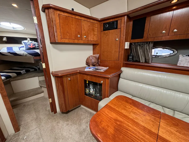 Slide: The Image of Interior of 2005 Cruisers Yachts 440 Express, featuring wood cabinetry and cozy seating area. - 20