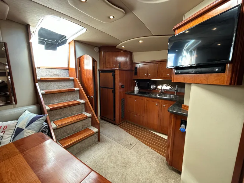 Slide: The Image of Interior of 2005 Cruisers Yachts 440 Express with kitchen, stairs, and TV. - 21