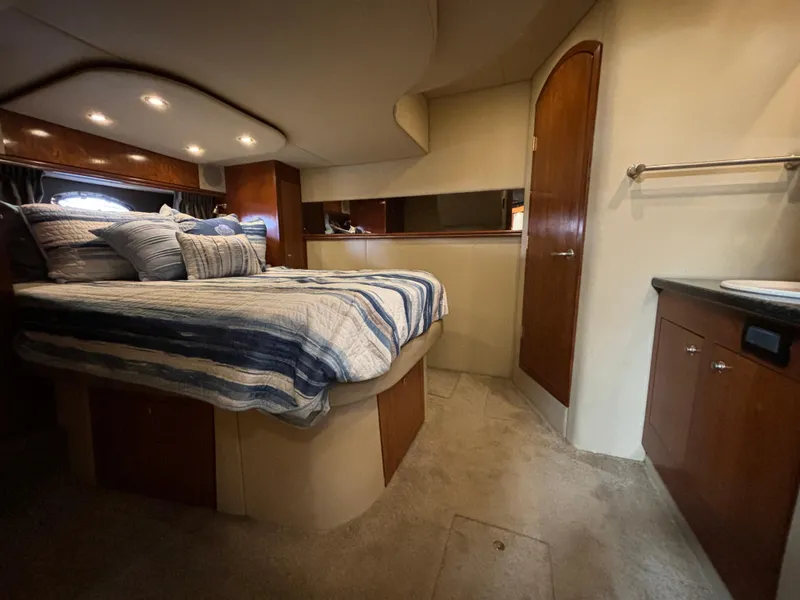 Slide: The Image of Luxurious 2005 Cruisers Yachts 440 Express cabin with cozy bed and elegant wood finishes. - 23
