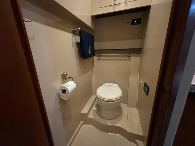 Slide: The Image of 2005 Cruisers Yachts 440 Express bathroom with toilet, towel, and toilet paper holder. - 26