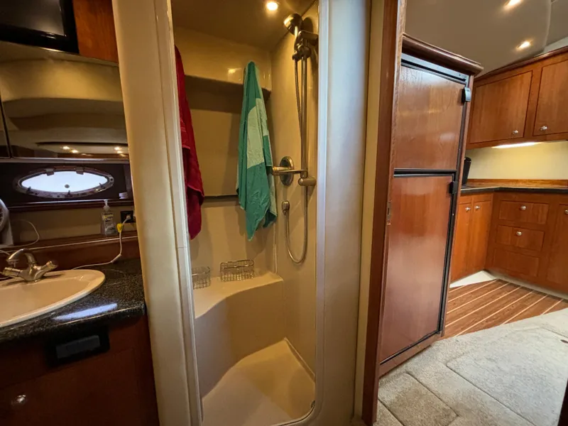 Slide: The Image of 2005 Cruisers Yachts 440 Express interior with shower, sink, and wooden cabinetry. - 27