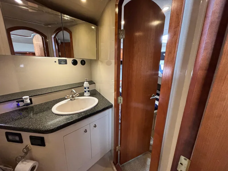 Slide: The Image of Bathroom interior of 2005 Cruisers Yachts 440 Express with sink and wooden door. - 28