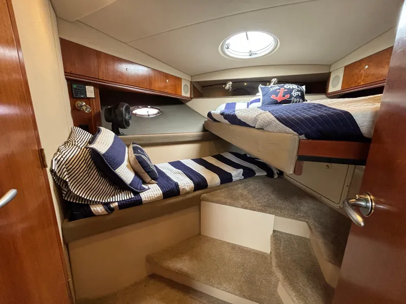 Slide: The Image of 2005 Cruisers Yachts 440 Express cabin with striped bedding and nautical decor. - 31