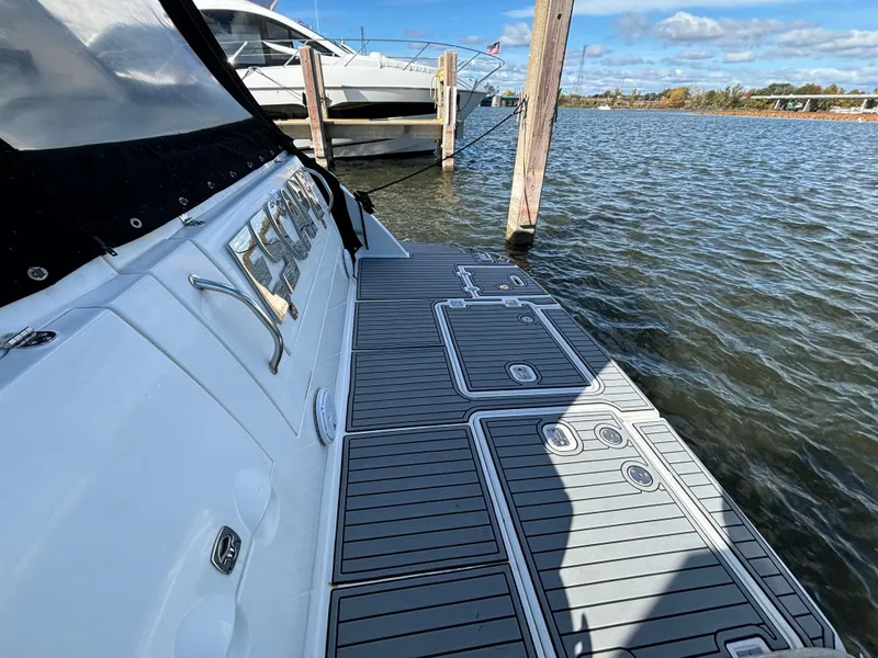 Slide: The Image of 2005 Cruisers Yachts 440 Express docked on a sunny day by the water. - 7