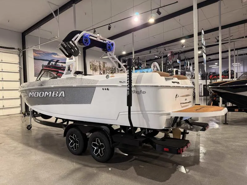 Slide: The Image of 2025 Moomba Mojo boat in showroom, featuring sleek design and modern trailer. - 18