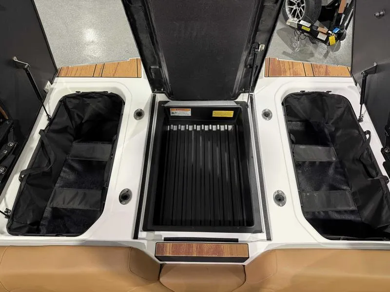 Slide: The Image of 2025 Moomba Mojo boat storage compartments with open lids, showcasing spacious interior design. - 21