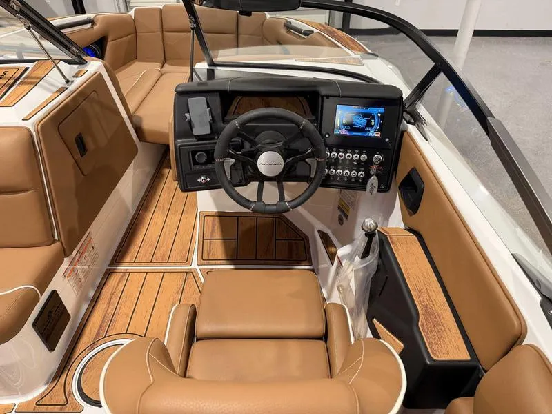 Slide: The Image of 2025 Moomba Mojo boat interior with tan seats, modern dashboard, and wood accents. - 7