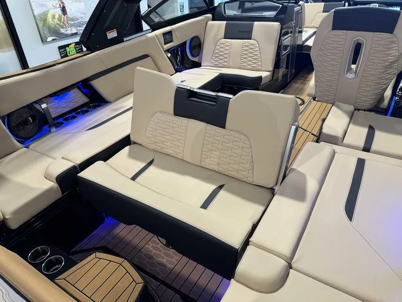 Slide: The Image of 2025 MasterCraft X24 boat interior with luxurious beige seating and ambient blue lighting. - 14