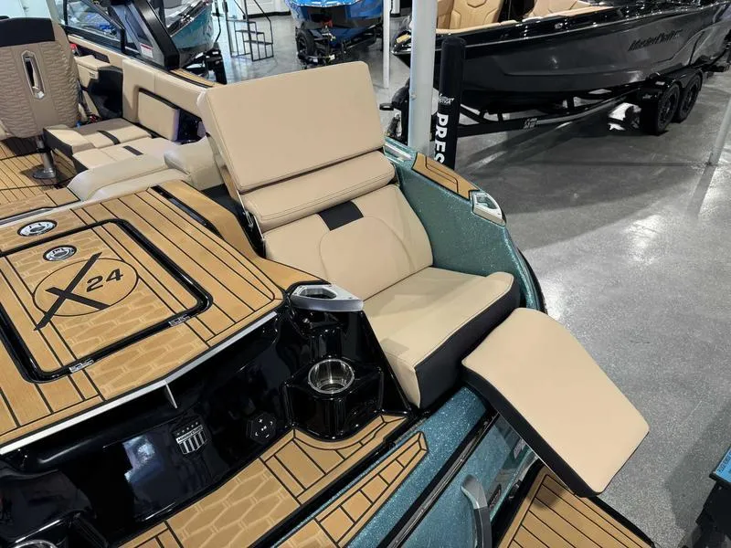 Slide: The Image of 2025 MasterCraft X24 boat interior with tan seating and cup holders. - 15