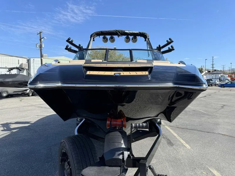 Slide: The Image of 2025 MasterCraft X24 boat on trailer, viewed from the front in a parking lot. - 3