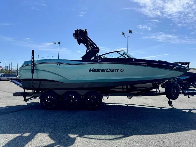 Slide: The Image of 2025 MasterCraft X24 boat on trailer under clear blue sky. - 4