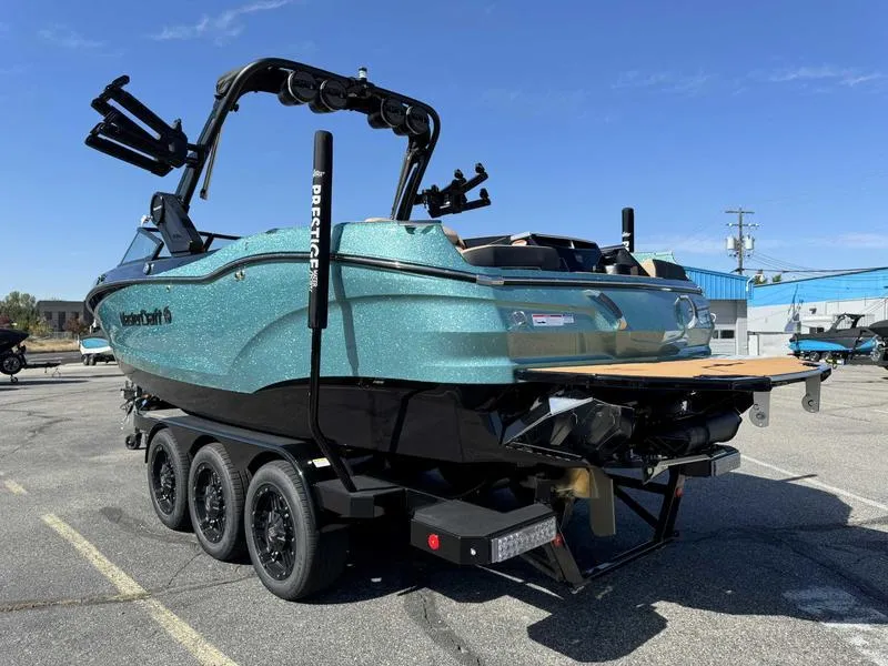 Slide: The Image of 2025 MasterCraft X24 boat on trailer, parked outdoors under clear blue sky. - 5
