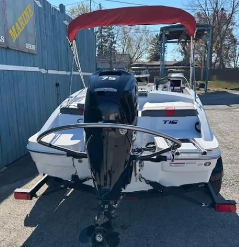 Slide: The Image of 2025 Tahoe T16 boat with outboard motor and red canopy in a marina setting. - 2