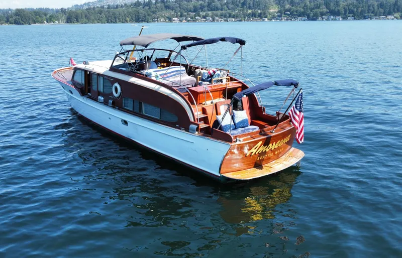 Slide: The Image of 1951 Chris-Craft Catalina boat on a lake, featuring classic wooden design and American flag. - 1