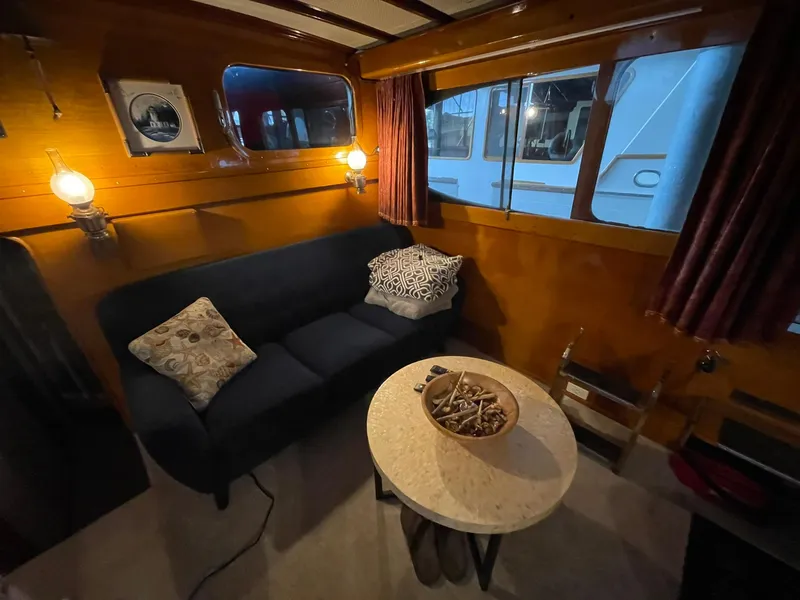 Slide: The Image of 1951 Chris-Craft Catalina interior with cozy seating, round table, and nautical decor. - 10