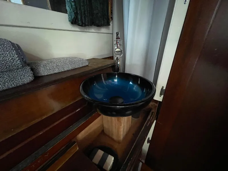 Slide: The Image of 1951 Chris-Craft Catalina interior with modern blue vessel sink and wooden cabinetry. - 19