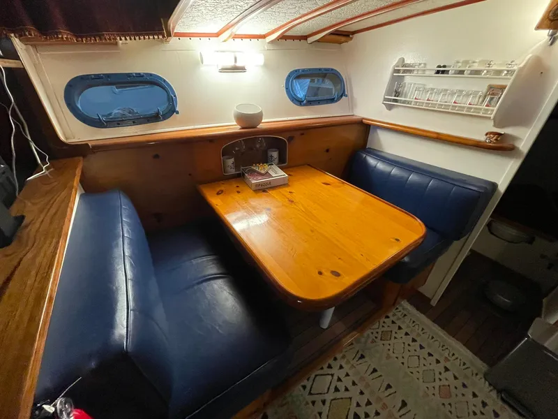 Slide: The Image of 1951 Chris-Craft Catalina interior with wooden table, blue seating, and nautical decor. - 2