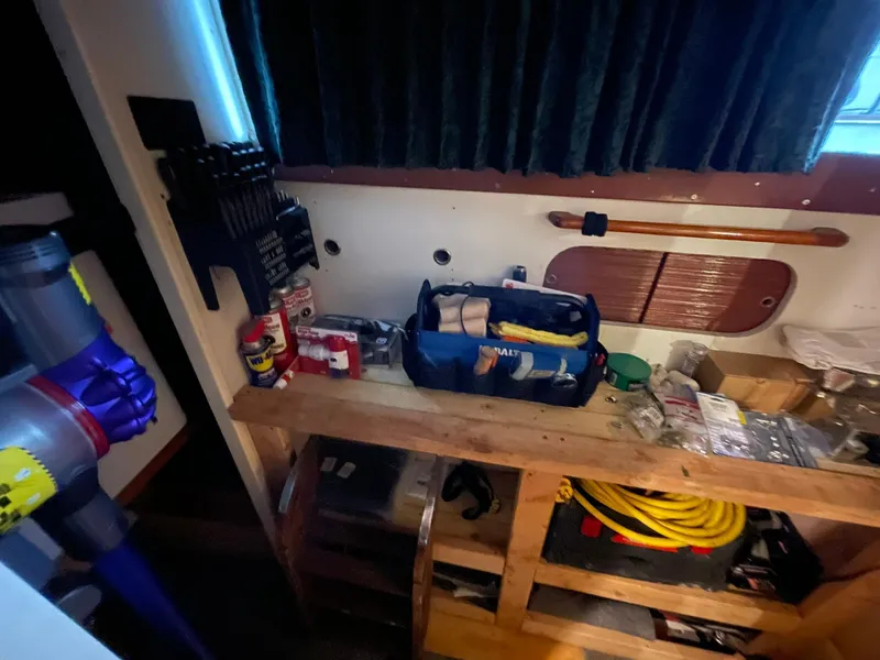 Slide: The Image of Interior of a 1951 Chris-Craft Catalina boat with tools and supplies on a wooden shelf. - 22