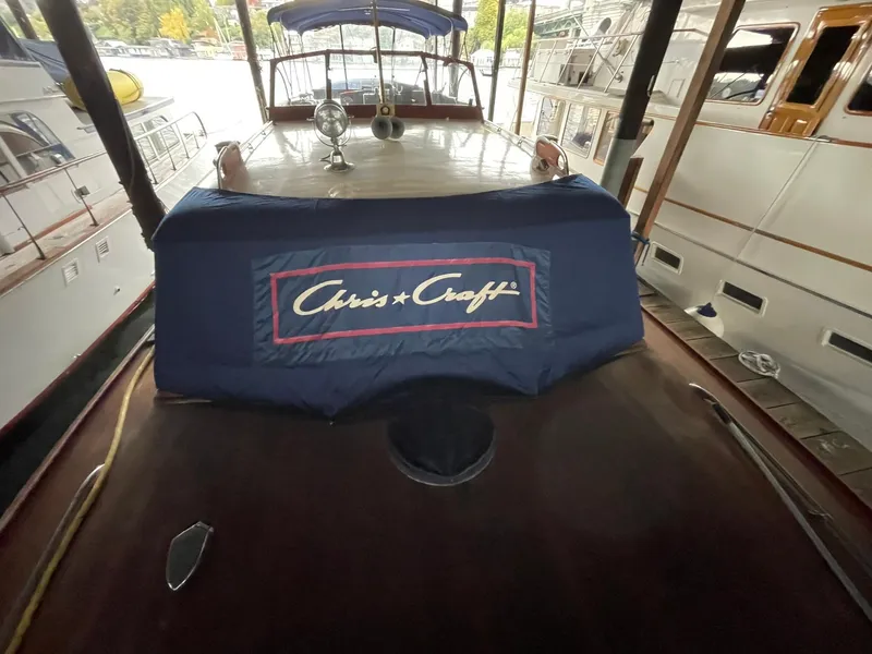 Slide: The Image of 1951 Chris-Craft Catalina boat with cover, docked in a marina. - 26