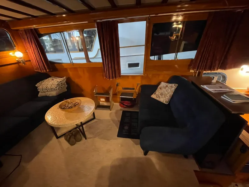 Slide: The Image of 1951 Chris-Craft Catalina interior with cozy seating, wooden paneling, and ambient lighting. - 3