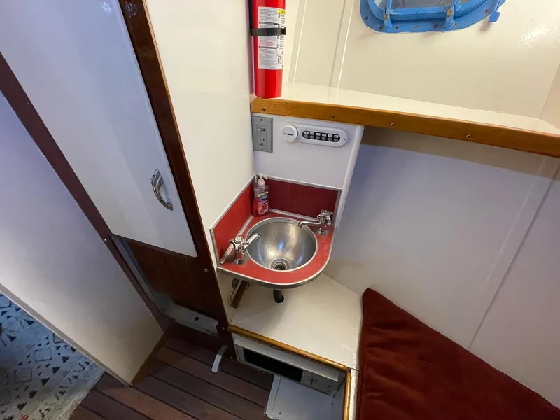 Slide: The Image of 1951 Chris-Craft Catalina interior with compact sink, fire extinguisher, and wooden flooring. - 33
