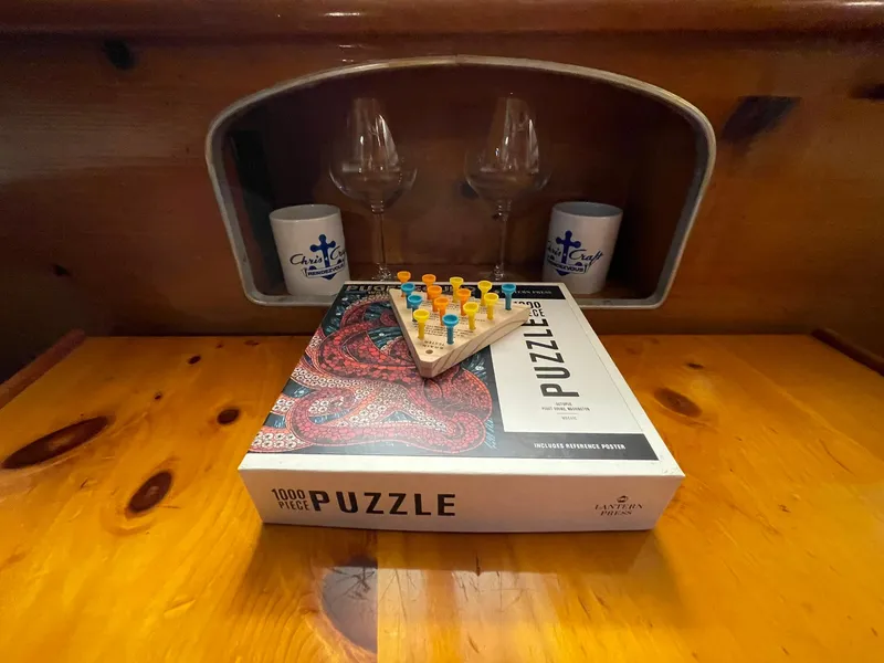 Slide: The Image of 1951 Chris-Craft Catalina interior with puzzle box and peg game on wooden table. - 7