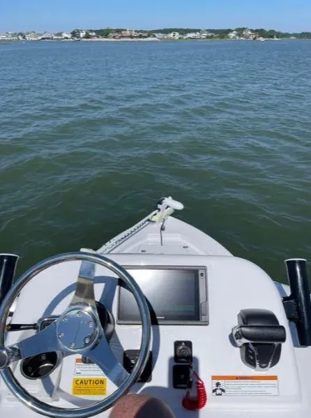 Slide: The Image of 2021 Sportsman MASTERS 247 BAY boat dashboard with steering wheel on open water. - 5